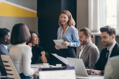 Happy group of business people discussing strategy during team meeting at the office together